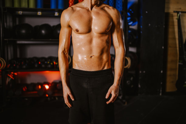 一个赤裸上身的肌肉运动员站在健身房的剪影照片图片下载