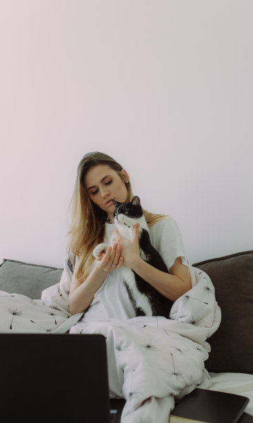 有文字位置的照片。高效的年轻千禧女孩早上坐在床上，使用笔记本电脑。有文字位置的照片图片下载