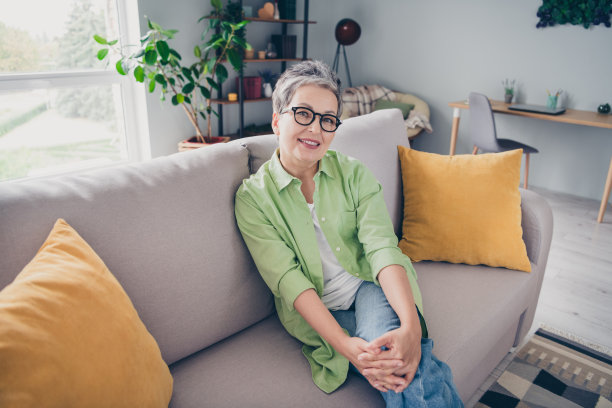 迷人的老年商务女士白发照片坐在沙发上休息愉快的正面做客她的家人在家里图片下载
