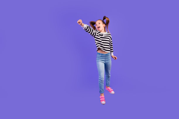 全长照片积极时髦的小孩子穿着条纹套头衫跳跃飞行空空间孤立的紫色背景图片下载