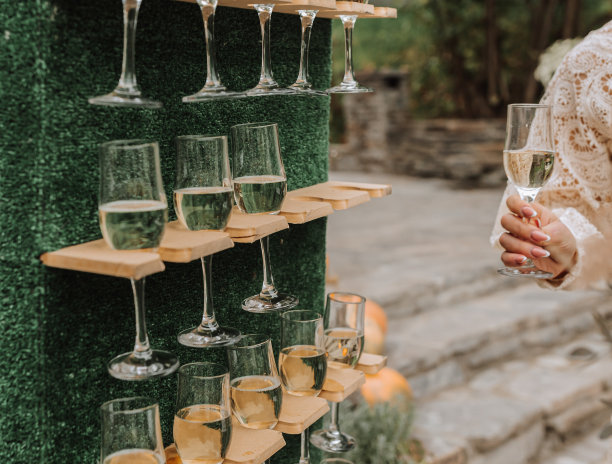 架子:放眼镜的架子奢华的婚礼。浪漫的婚礼仪式。户外用绿色植物装饰的婚礼拱门-库存照片图片下载