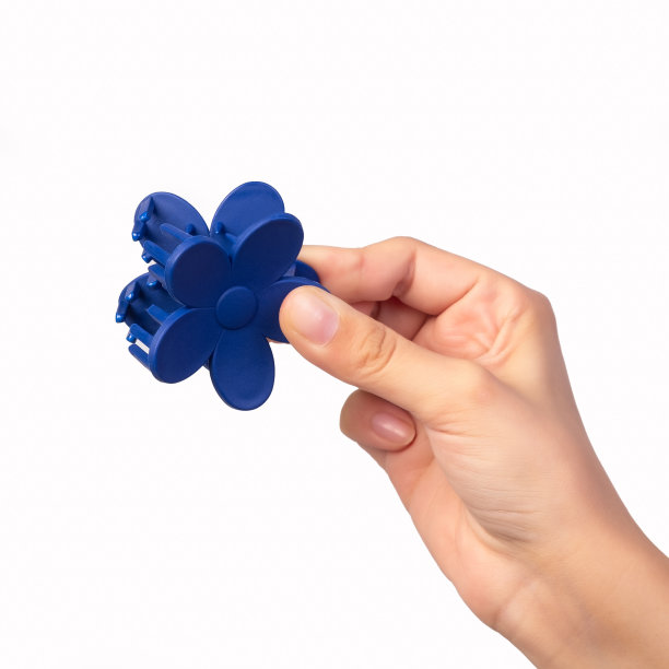 这个年轻女孩手里拿着一个蓝色的发夹。图片下载