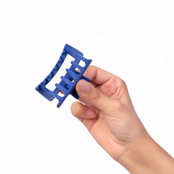 这个年轻女孩手里拿着一个蓝色的发夹。图片下载