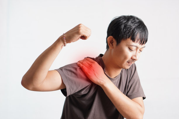 亚洲男人有结构性姿势问题他肩膀疼。他按摩肩膀以减轻疼痛。减少肌肉紧张图片下载