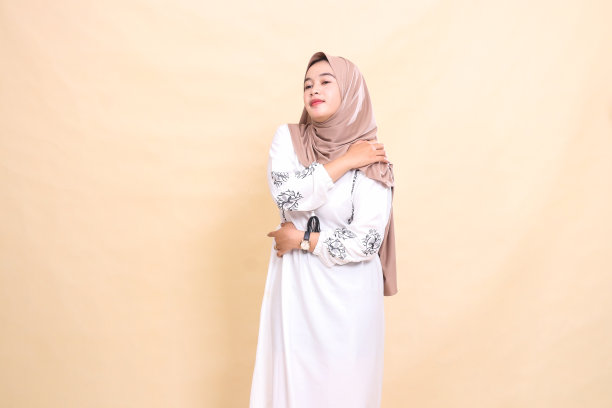 一名亚洲穆斯林成年妇女的偷拍照片，她戴着头巾，肩膀酸痛。用于广告、健康、科学和斋月图片下载