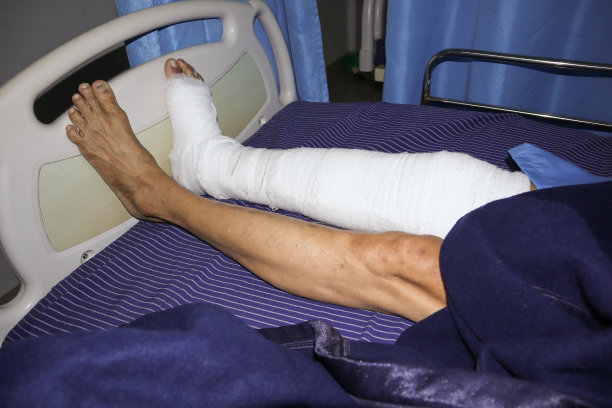 在印度，因意外受伤而接受脚踝手术的人腿裹着胶布的特写照片。图片下载
