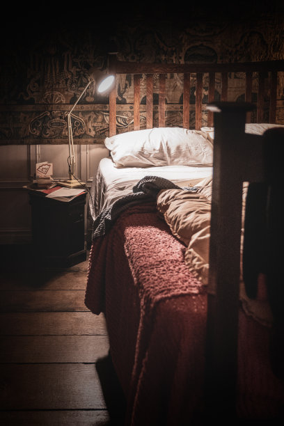 角度平衡阅读灯在一个古老的床与被子图片下载