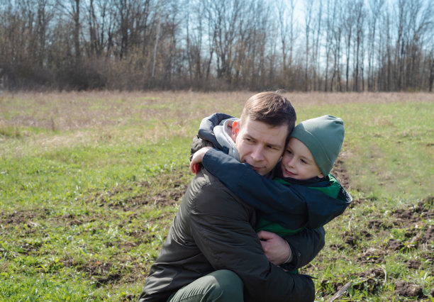 爸爸和儿子在户外度过时光。父亲和儿子拥抱的照片图片下载