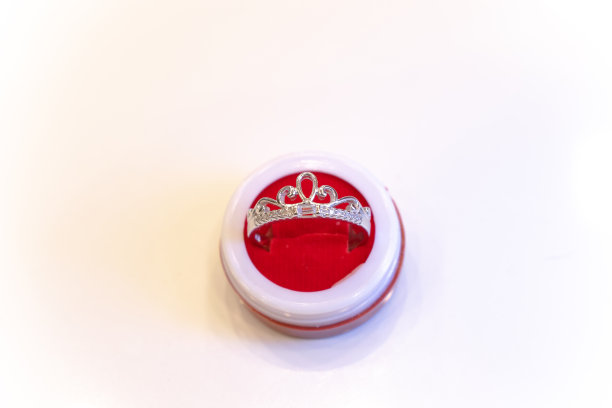 一枚戒指装在白底盒子里的照片。银、金、铂金、时尚、链条、珠宝、女孩、女人、印度、亚洲、价格、下跌、股票、市场、象征、爱情、礼物、订婚。图片下载