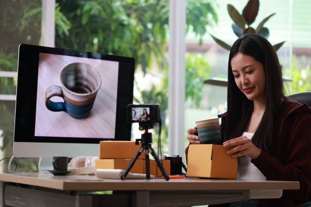 一个漂亮的女人经营着一家电子商务公司，她将商品打包并运送给顾客。图片下载