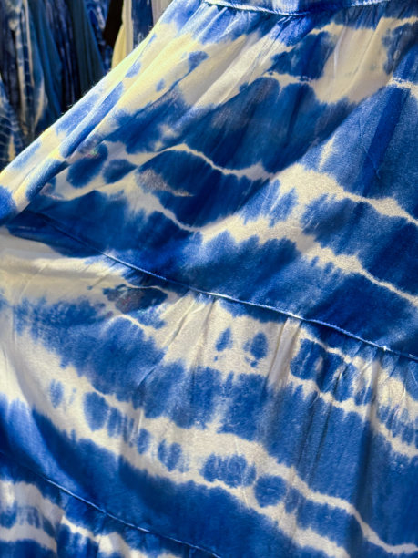 定制的特写图像，蓝白色领带染色牛仔背心裙，沙滩服冲浪服挂在服装百货商店，时尚休闲服装，重点在前景图片下载