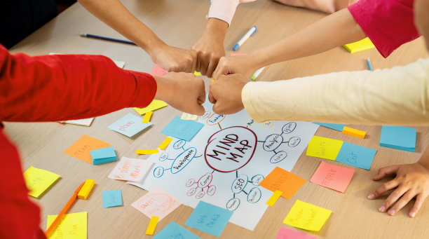 年轻的创意创业团队加入圆圈，一起握拳。斑叶。图片下载