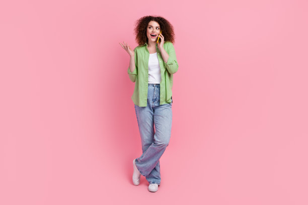 微笑的商务女士的全身照片看起来空的空间有一个电话对话惊讶孤立在粉红色的背景图片下载