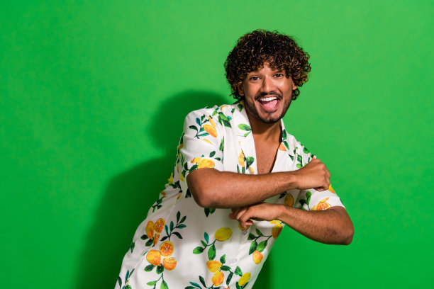 有魅力的年轻人跳舞的照片肖像有乐趣穿着时尚的柑橘印花衣服孤立的绿色背景图片下载