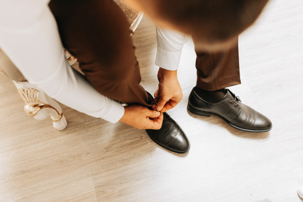 新郎正在一间豪华的酒店房间里穿衣服，为婚礼做准备图片下载