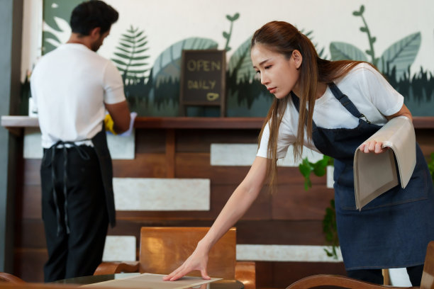 咖啡馆老板商人咖啡师员工年轻的亚洲妻子铺着桌布和年轻的多国丈夫桌子在后面摆着两个咖啡店的小生意图片下载