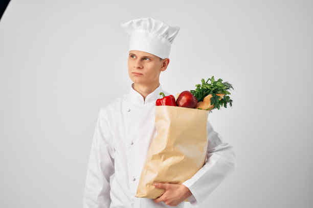 一个穿着厨师制服的人拿着餐厅工作服务的成套产品图片下载