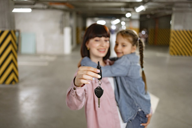白人妇女在地下停车场拿着女孩子和车钥匙。图片下载