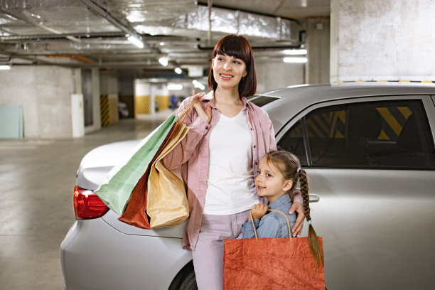 白人母亲和女儿提着在商场买的衣服。图片下载