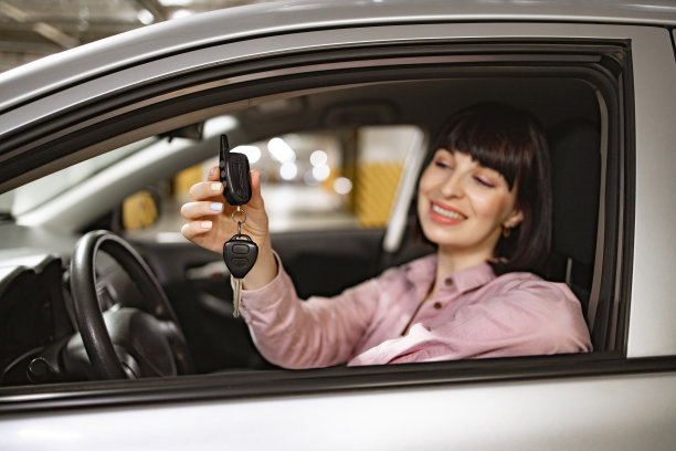 穿着休闲服的白人妇女坐在现代汽车的方向盘后面。图片下载