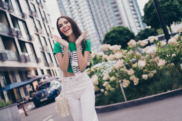 照片中，年轻漂亮的女士穿着时尚的衣服，带着新的配饰品牌手袋，惊讶的双手脸颊享受着基辅城图片下载