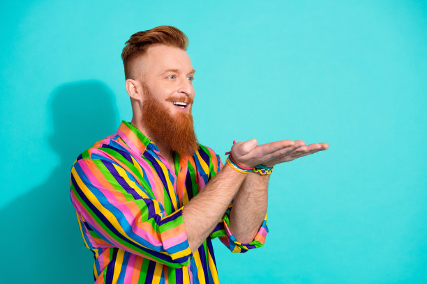 照片的积极高兴的男人穿着时尚的衣服，展示空白空间化妆品头发胡须护理孤立的青色背景图片下载