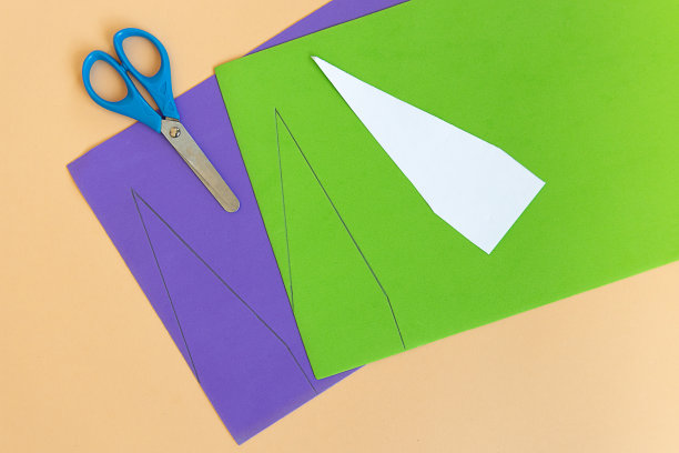 狂欢节小丑头上戴着纸做的帽子。一步一步的照片说明DIY从9个步骤在中性背景。9中的第三步。图片下载