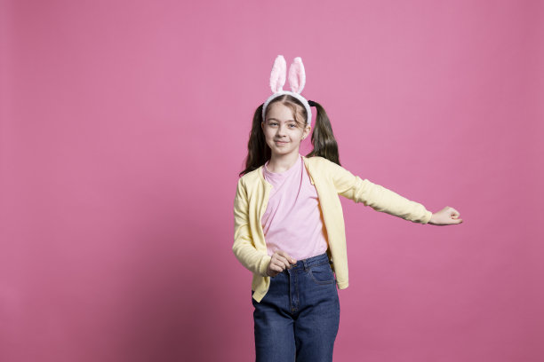 无忧无虑的小女孩在镜头前戴着兔子耳朵，表现得很积极图片下载