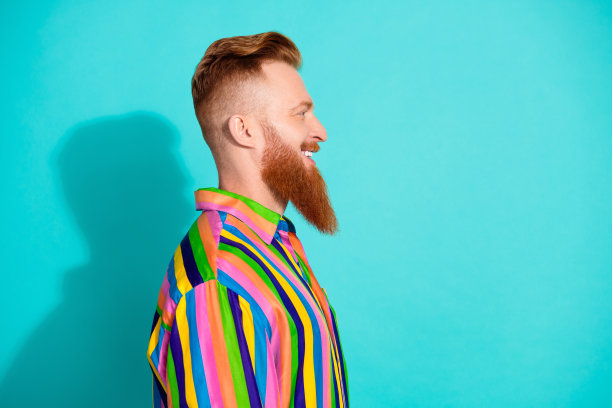 侧面照片正面的好男人穿着时髦生动的衣服看起来空的空间产品孤立在青色的背景图片下载