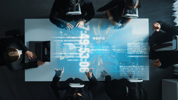 俯视图的经理使用笔记本电脑发送数据，而团队戴上vr。理事会。图片下载