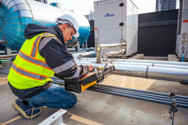 这张照片拍摄的是一位技术熟练的工程师在检查石化设备中的管道网络。具有与石化、工程和工业检验相关的项目概念。图片下载