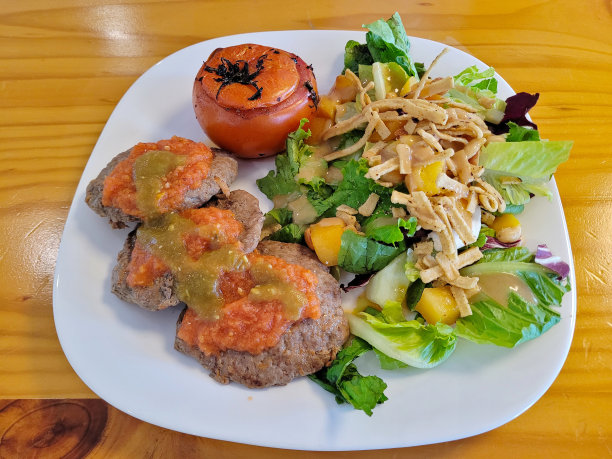 烤牛肉饼配莎莎酱，烤番茄和沙拉图片下载