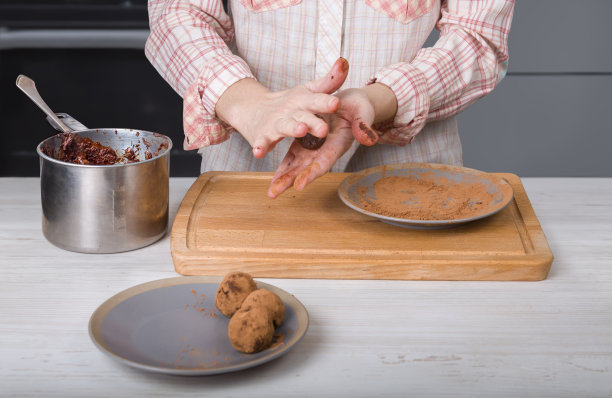 一位女士在现代化的厨房里烹饪巧克力松露。图片下载