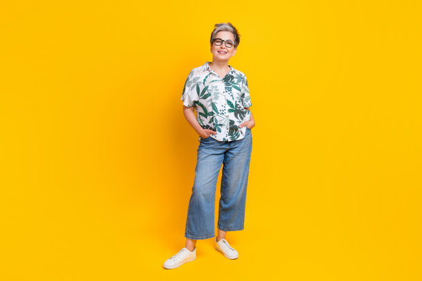 漂亮的退休女士双手口袋的全身照片摆造型模特穿着时尚的热带印花服装孤立在黄色背景图片下载