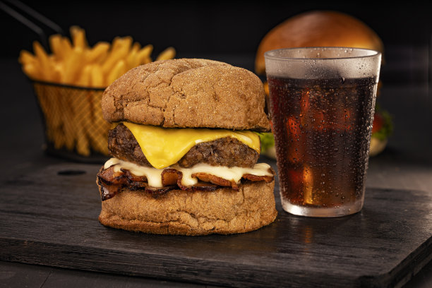 汉堡配薯条和苏打水，在摄影棚里用棕色和黑色的木头拍的照片图片下载