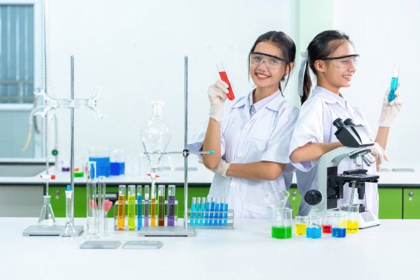 两名亚洲女科学家是在医院实验室成功研制出新型冠状病毒药物和疫苗的医生。有一个显微镜。烧杯被派去治疗病人。图片下载