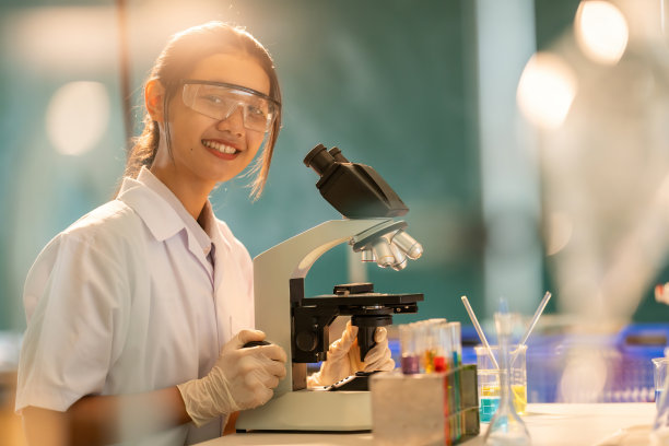 在世界卫生组织药学系化学实验室工作的亚洲女科学家中景。用显微镜生产COVID-19疫苗让医生治疗病人图片下载