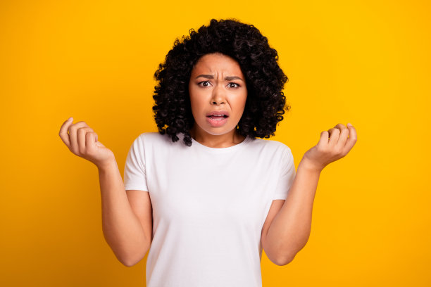 失望沮丧的烫发女人的照片，穿着白色t恤，要求听到她孤立的黄色背景图片下载