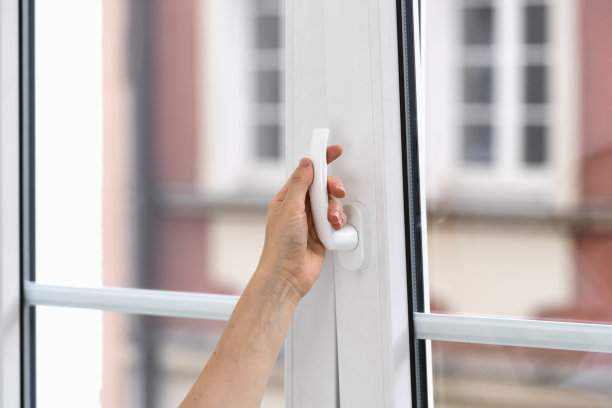 选择性地关注女性在公寓里转动手柄和打开窗户的手。图片下载