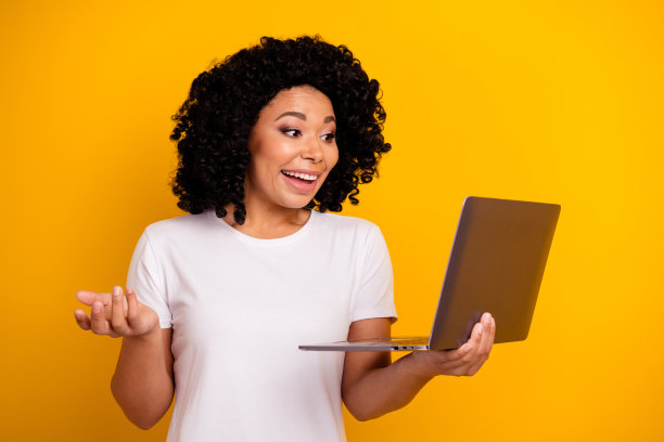 穿着白色t恤的烫发美女的照片，在黄色背景上孤立的笔记本电脑上进行远程会议图片下载