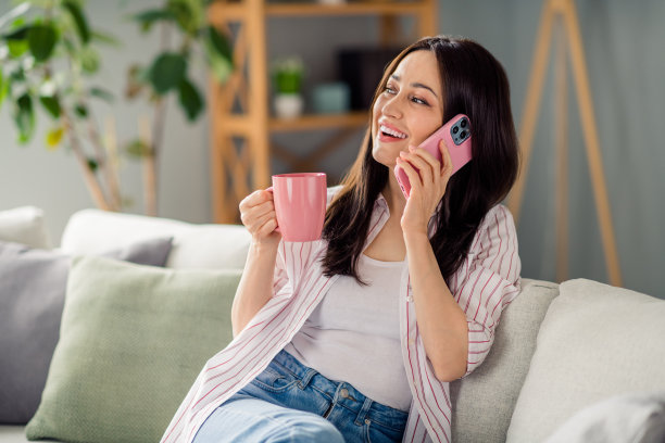 宁静的好人照片坐在沙发上拿着咖啡杯交流电话空闲时间冷藏室室内图片下载