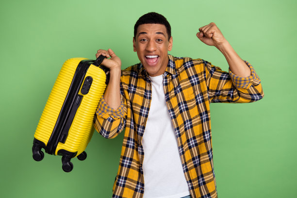 疯狂的喜悦的人的照片拿着行李箱举起拳头喊是的欢呼孤立在绿色的背景图片下载