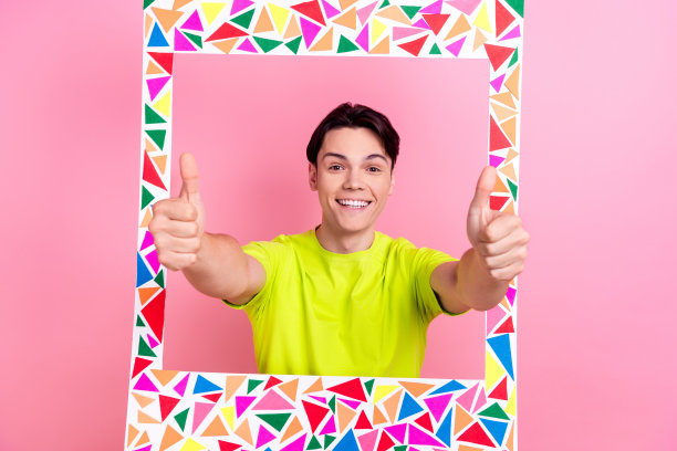 照片肖像英俊的青少年男性相框显示拇指向上穿着时尚的黄色服装孤立在粉红色的背景图片下载