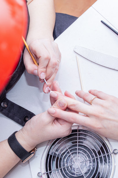 美甲师正在给一位女客户打理指甲，整理指甲，让指甲保持健康，特写照片图片下载