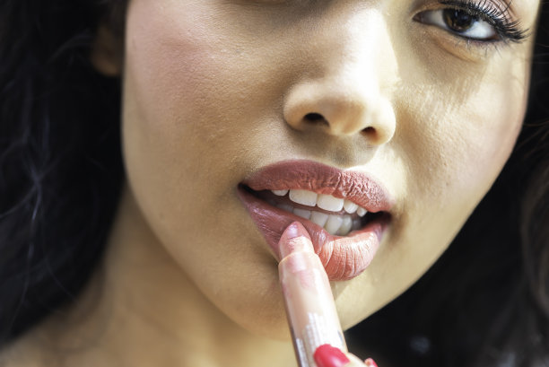 美容护肤女士拿口红的特写图片下载