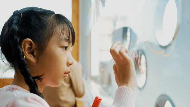 美术课上创意学生在玻璃板上画画的特写。博学。图片下载