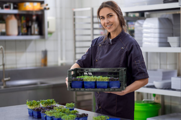 穿制服的女人在餐厅厨房拿着蔬菜图片下载