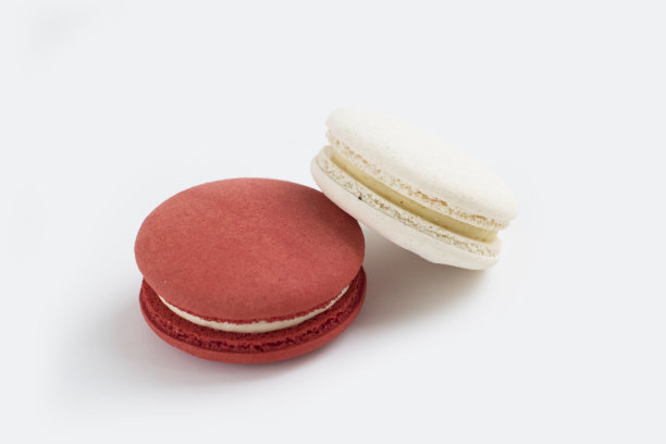 两个美味的法式甜点马卡龙的特写照片，香草和蔓越莓的味道。图片下载