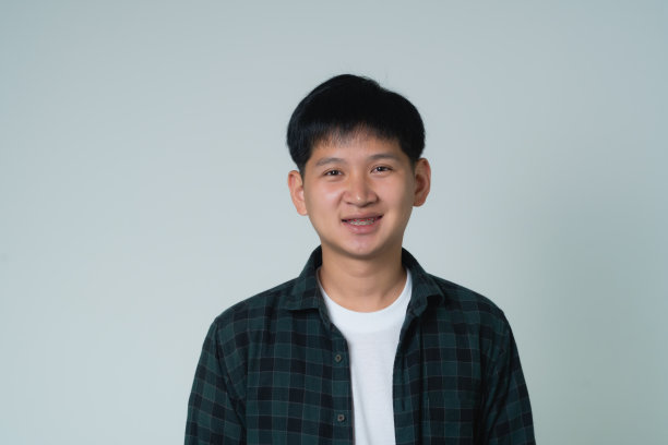 亚洲男人的牙套。牙齿套在人的白色牙齿上，使牙齿平衡。托架系统在微笑的嘴，近距离照片牙齿，微距拍摄，牙医的健康理念。图片下载