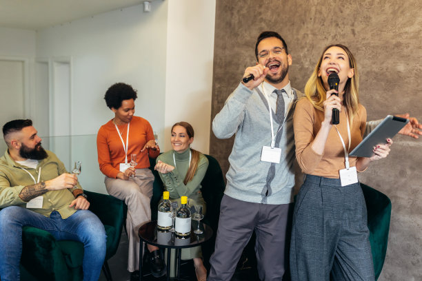 商务人士在团队建设研讨会上做团队训练练习，唱卡拉ok喝酒。图片下载